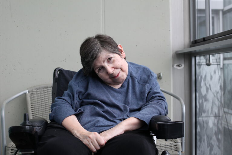 Bewohnerin Elfriede sitzt in ihrem Rollstuhl auf ihrem Balkon im HB Seeböckgasse.
