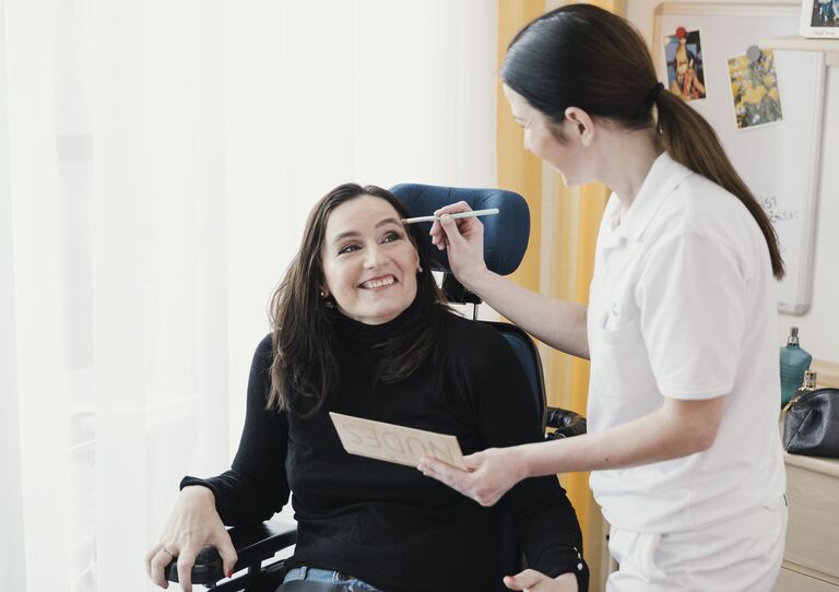 Bewohnerin Elke wird geschminkt.