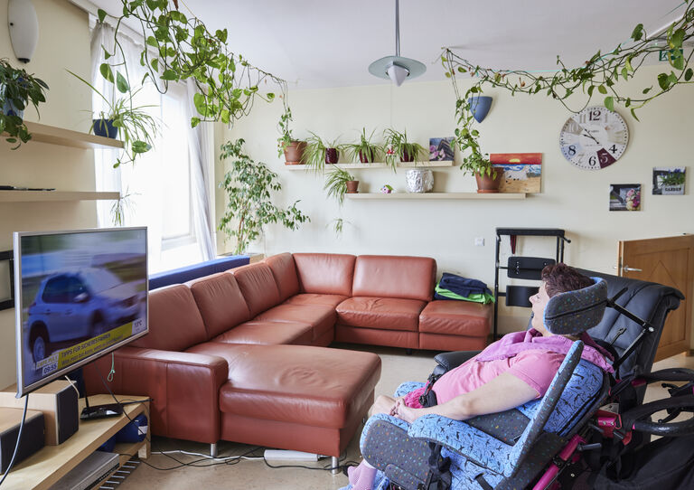 Kundin sieht fern im Wohnzimmer der HABIT WG Perfektastraße