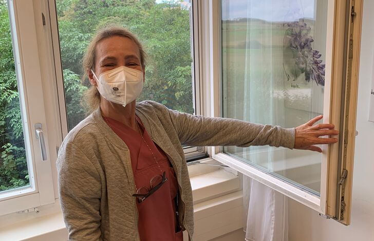 Eine Kollegin öffnet das Fenster. 