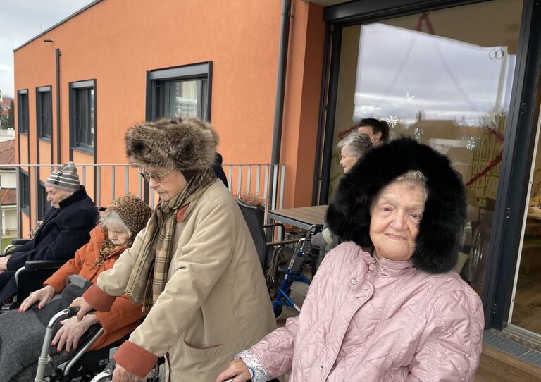 Einige Bewohner*innen am Balkon, die dem Konzert lauschen.