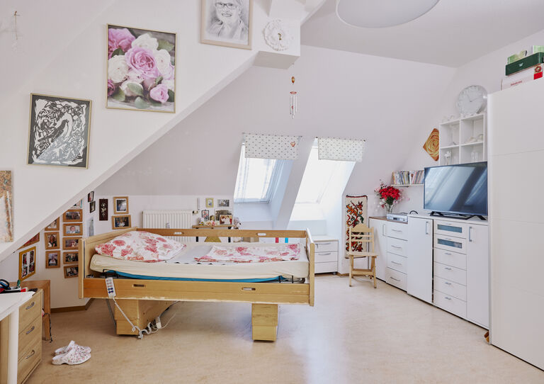 Individuell eingerichtetes helles Kund*innen-ZImmer mit Dachschräge in der HABIT WG Oswaldgasse