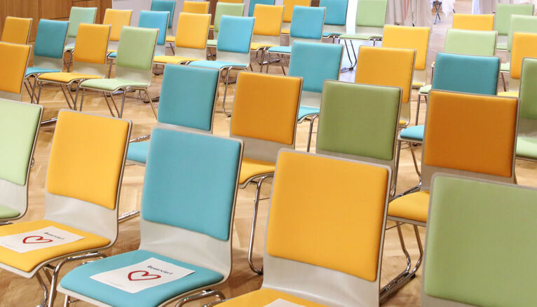 Bunte Stühle in einem Seminarraum.