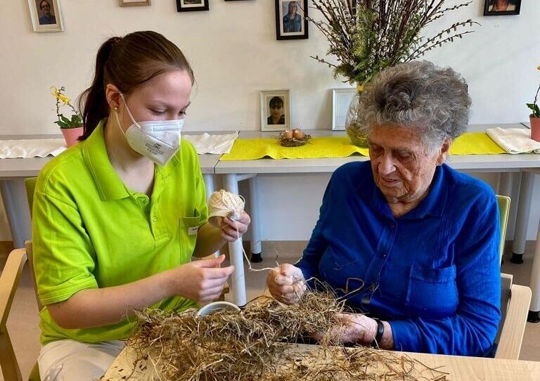 Bewohnerin bastelt Kranz.
