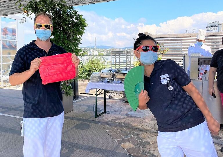 Zwei MitarbeiterInnen mit Sommeraccessoires.