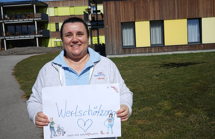 Mitarbeiterin hält Schild mit "Wertschätzung"