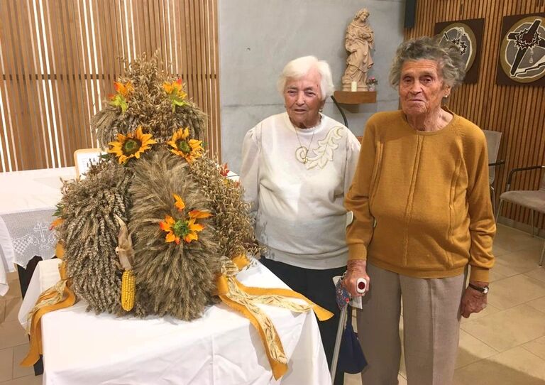 Zwei Bewohnerinnen des Stephansheims stehen neben der Erntedankkrone.