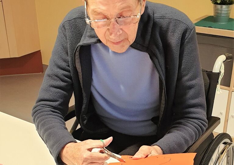 Ein Bewohner schneidet Dekoration aus.