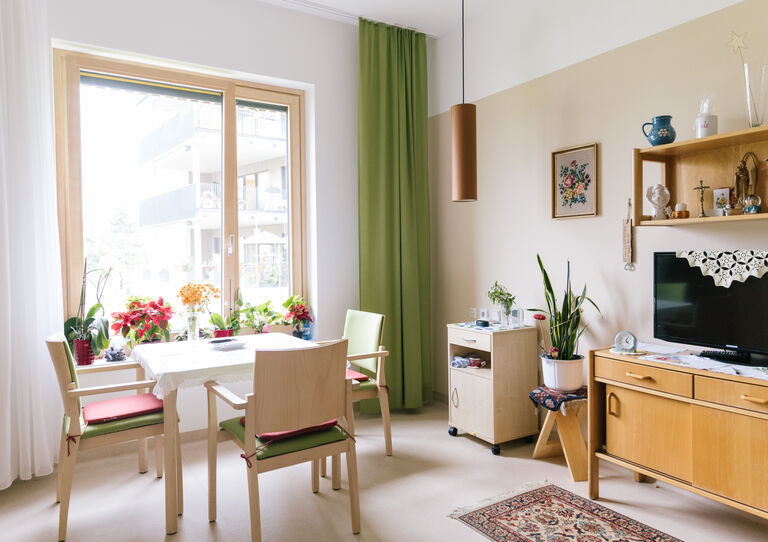 Ein Wohnbereich im Stephansheim mit Sitzecke und Fernseher.