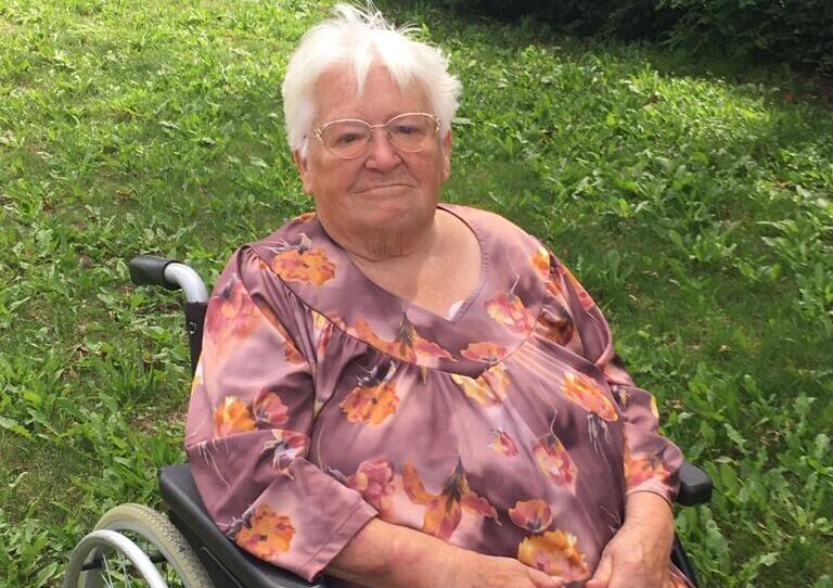 Bewohnerin im Rollstuhl lächelt in die Kamera