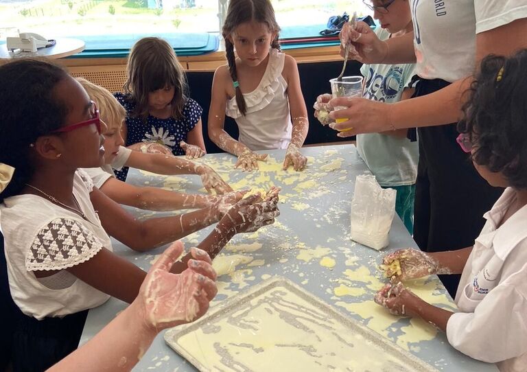 Die Kinder backen gemeinsam mit einer Mitarbeiterin Pizza.