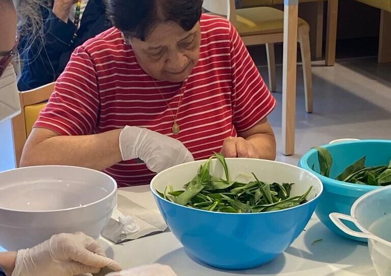 Eine Bewohnerin schneidet den Bärlauch