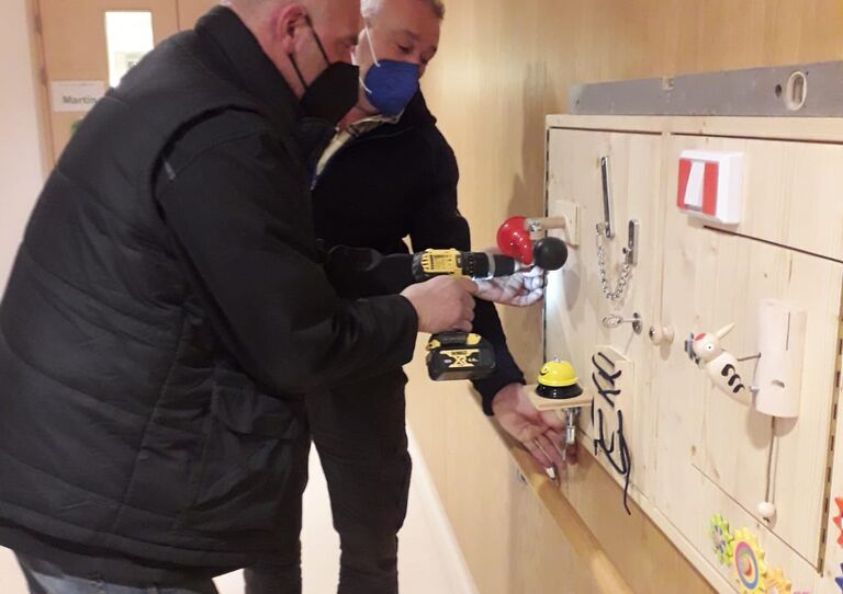 Zwei Ehrenamtliche Mitarbeiter montieren die Wand.