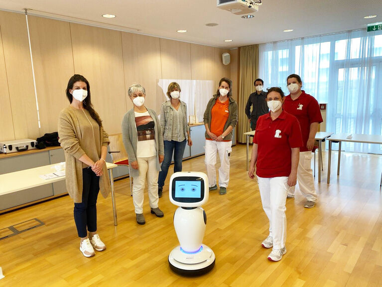 Veronika Schauer mit einigen Kolleg*innen und dem Roboter James