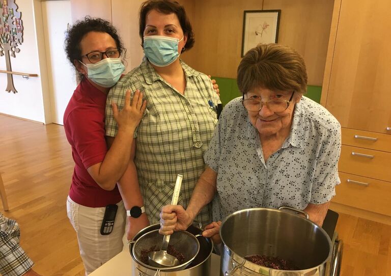 Bewohnerin und zwei Mitarbeiterinnen kochen Lavendel ein.
