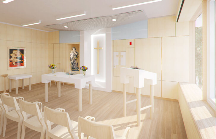 Die helle Kapelle mit dem Altar, einem großen schlichten Holzkreuz und Marienstatue.