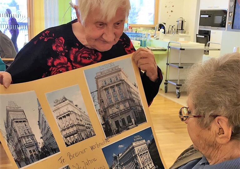 Maria zeigt das fertige Plakat einer Mitbewohnerin.