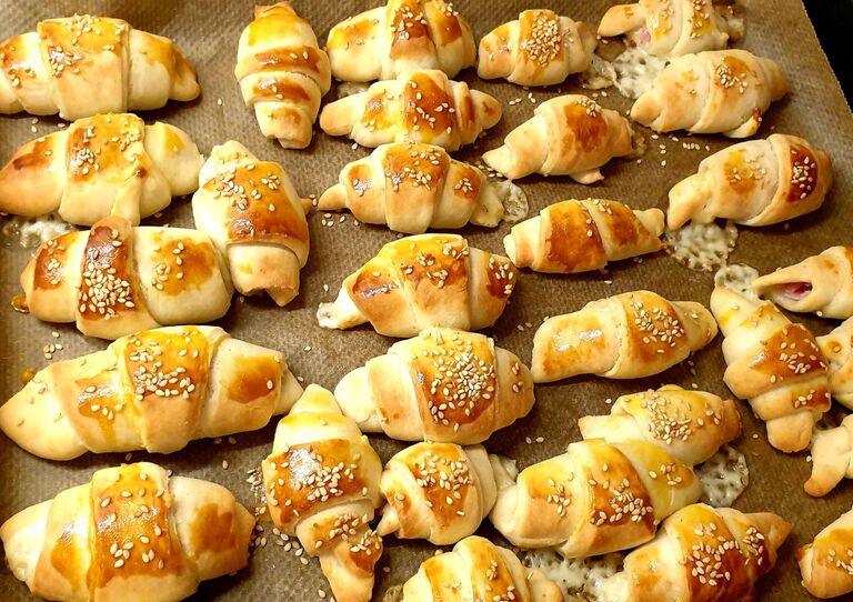 Die frischen Schinken-Käse-Kipferl fertig auf dem Backblech.