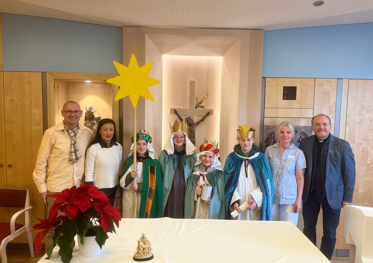 Sternsinger*innen besuchen das Haus der Barmherzigkeit Am Maurer Berg St. Josef und haben sich mit Mitarbeiter*innen aus dem HB zu einem Gruppenfoto formiert