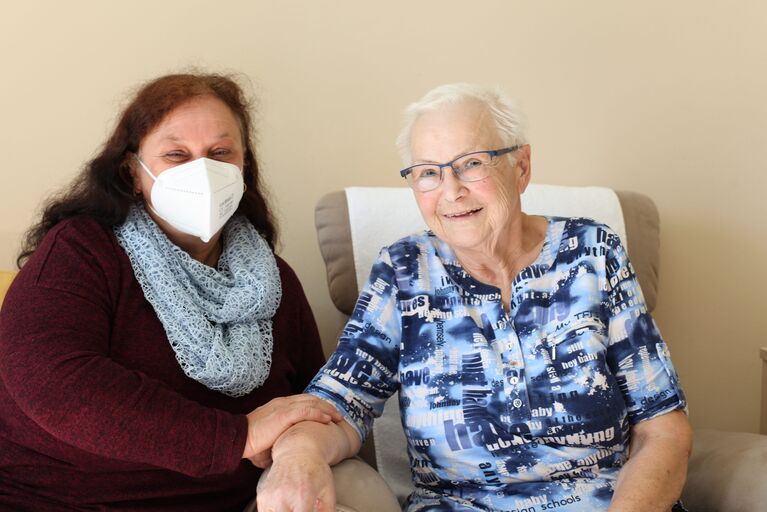 Tochter Waltraud und Bewohnerin Waltraud halten Hände.