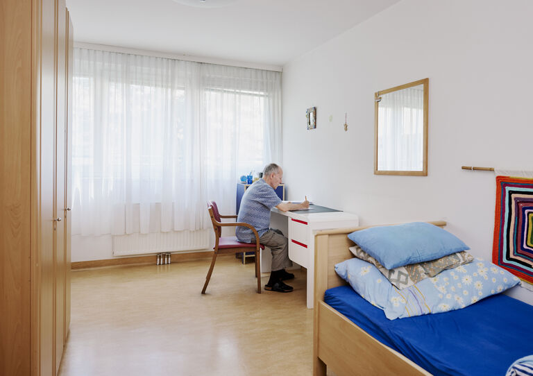 Kunde sitzt am Schreibtisch in seinem Zimmer in der WG Schanzstraße