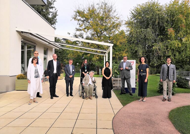 Prim. Dr. Barbara Schreiber, Prim. Dr. Michael Smeikal, Institutsdirektor Christoph Gisinger, eine Bewohnerin des Hauses, die Pianistin, Stadtrat Peter Hacker, Mezzosopranistin Christina Sidak und Bariton Christoph Filler vor dem HB Tokiostraße