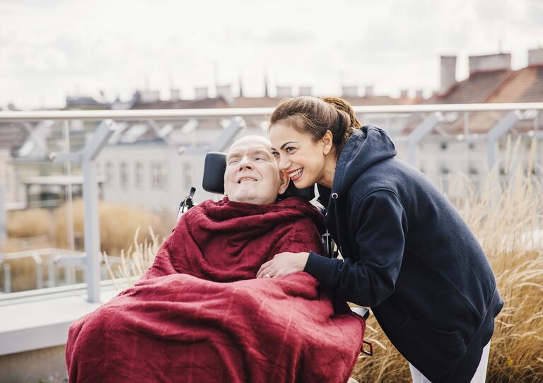 Wachkoma Patient Paul mit Mitarbeiterin auf der Dachterrasse.