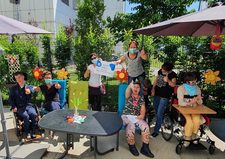 Die Mitarbeiterinnen und Kundinnen freuen sich über die großzügige Spende.