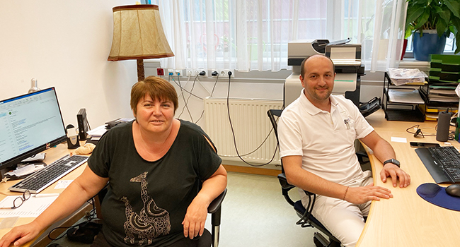 Gorica Popovic und ihr Kollege Asmir Tutic sitzend im Büro.